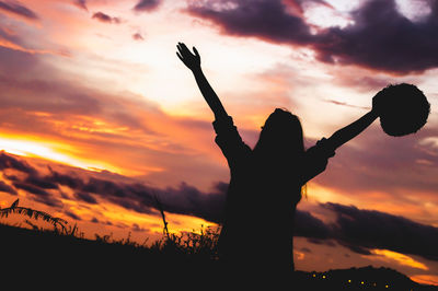 Silhouette woman standing by tree against sky during sunset