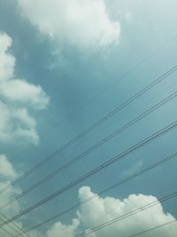 Low angle view of electricity pylon against blue sky