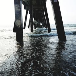 Wooden pier on sea shore against sky