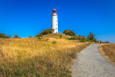 Lighthouse on field against sky