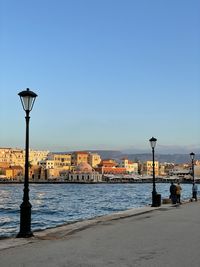 View of buildings by sea against clear sky
