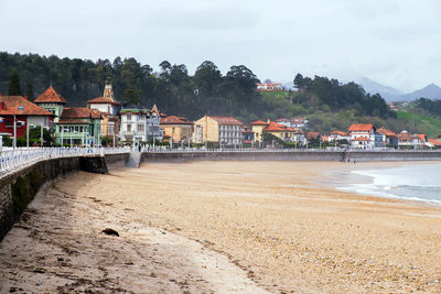 Houses by sea against sky