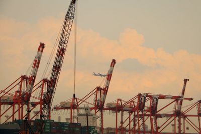 Cranes at construction site against sky