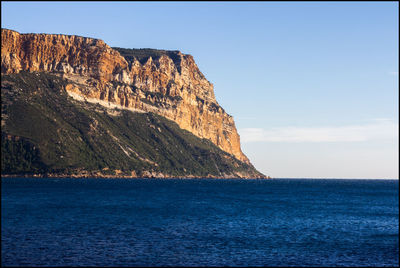 Scenic view of sea and mountains against sky