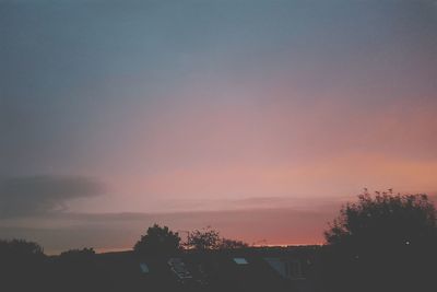 Silhouette trees and buildings against sky during sunset
