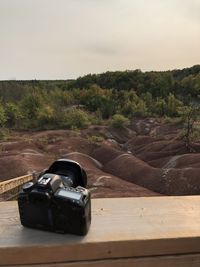 Close-up of camera on table against clear sky