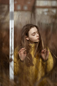 Portrait of young woman with reflection on glass