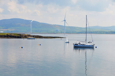 Boats in lake with mountains in background