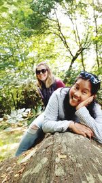 Portrait of a smiling young woman against trees