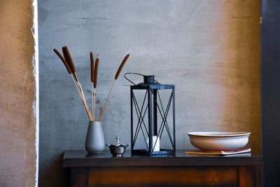 Candle on table against wall at home