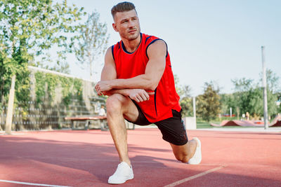 Portrait of young man exercising on road