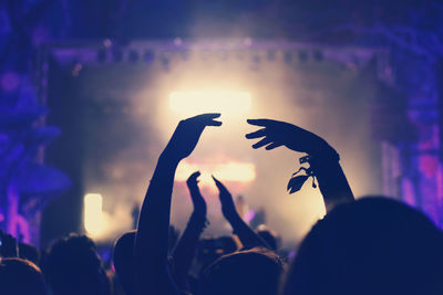 Silhouette people at music concert against sky at night