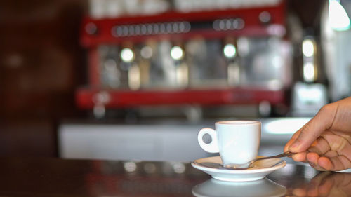 Hand holding coffee cup at cafe