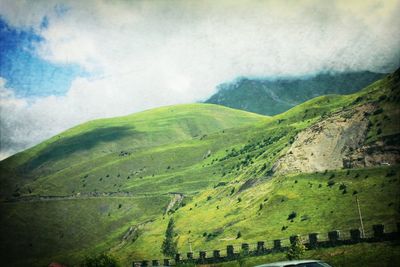 Scenic view of green landscape against sky
