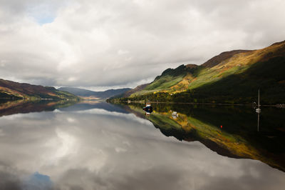 Scenic view of lake by mountains against sky