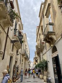 People on street amidst buildings in city