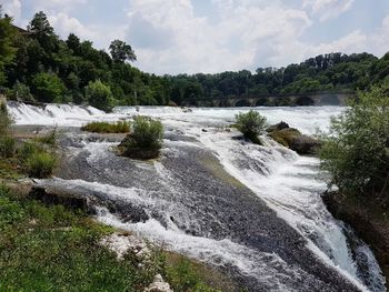 Scenic view of waterfall against sky