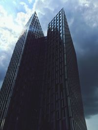 Low angle view of modern building against cloudy sky