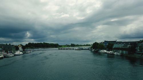 Bridge over river against cloudy sky