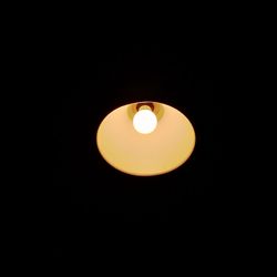 Low angle view of illuminated lamp against black background