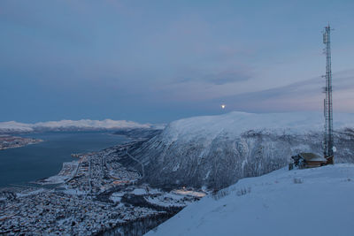 Town by fjord against sky seen from mountain peak