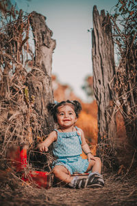 Portrait of cute girl sitting on tree