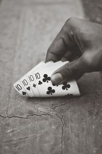 Cropped hand holding cards at table