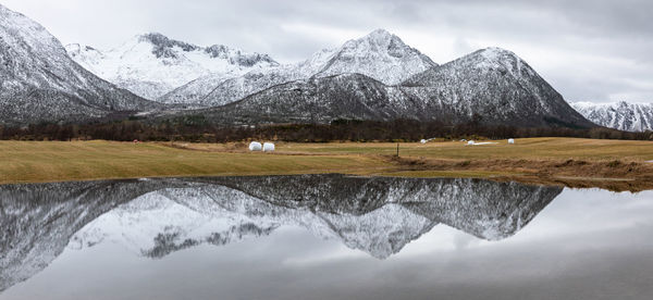 Scenic view of lake and snowcapped mountains against sky