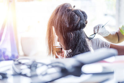 Hairdresser applies a hair mask to the woman in the beauty salon. 