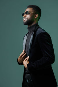 Young man standing against blue background