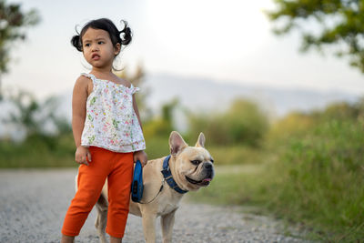 Cute girl with dog on dirt road