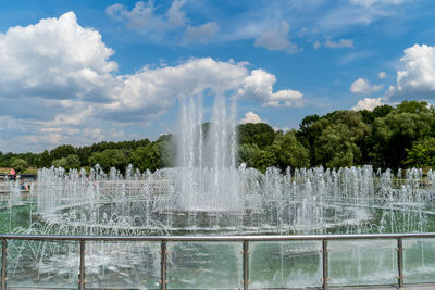 View of fountain in lake against cloudy sky