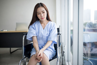 Young woman sitting on chair at home