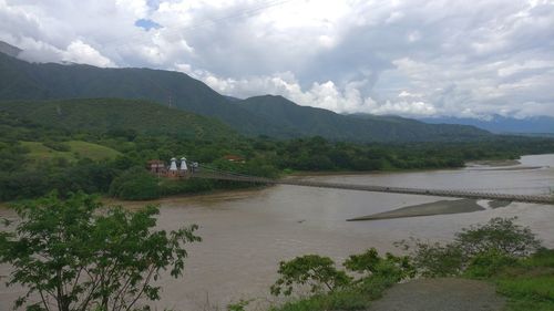 Scenic view of river and mountains against sky