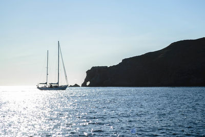 Sailboats sailing on sea against clear sky