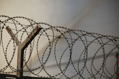 Low angle view of barbed wire against sky