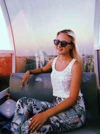 Young woman wearing sunglasses sitting outdoors