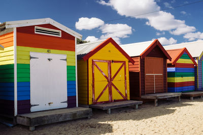 Multi colored beach huts against sky