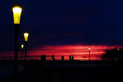 Silhouette people walking on street at night