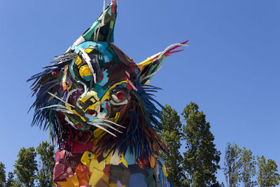 Low angle view of sculpture against clear blue sky