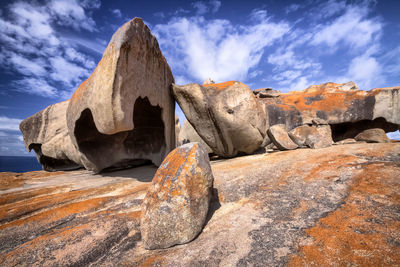 Rock formations on sea shore against sky