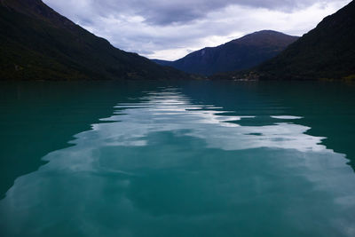 Scenic view of lake by mountains against sky