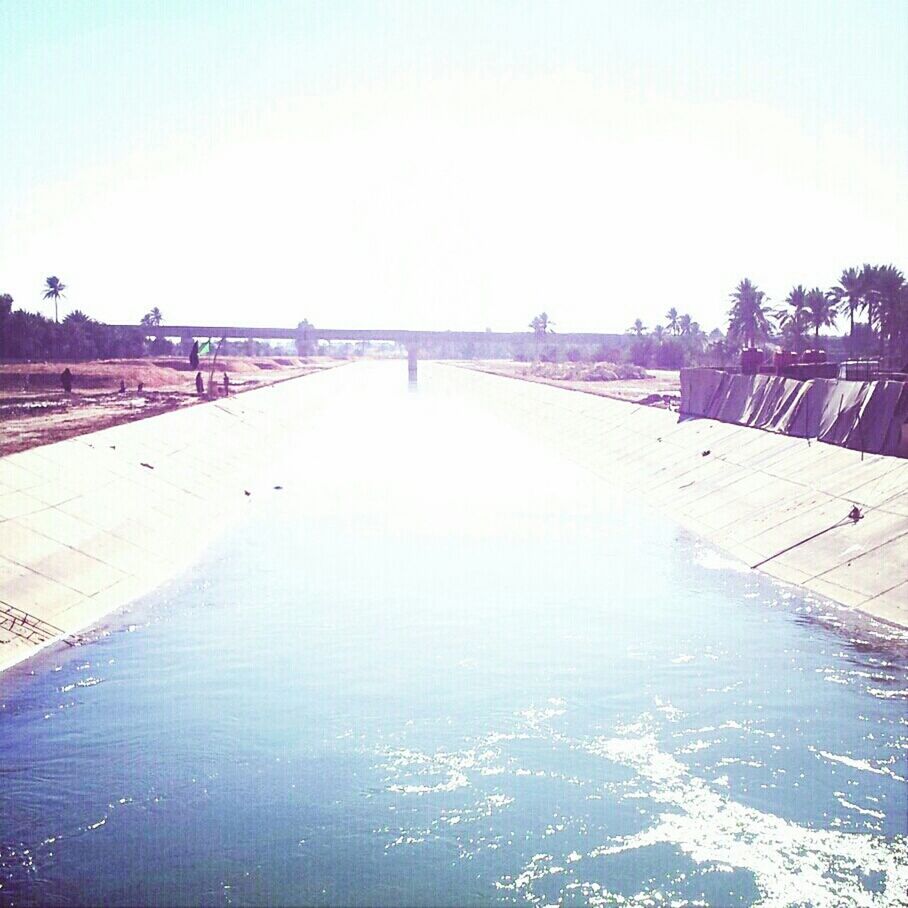 water, built structure, architecture, clear sky, sea, connection, bridge - man made structure, nature, scenics, incidental people, beach, tranquility, sky, copy space, tranquil scene, waterfront, outdoors, sunlight, transportation, river