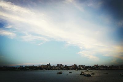 Boats in sea with city in background