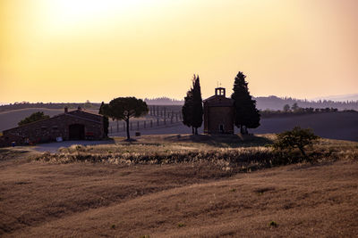 Built structure on land against sky during sunset