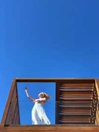 A woman in white dress against blue sky