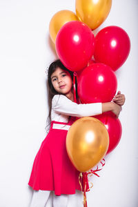 Portrait of a girl with balloons against white background