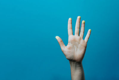 Cropped hand against blue background