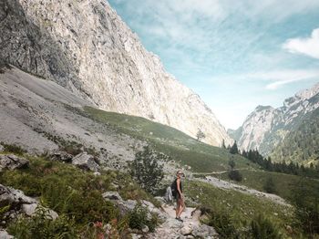 Full length of woman standing on landscape against mountain range