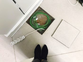 Low section of man standing on tiled floor